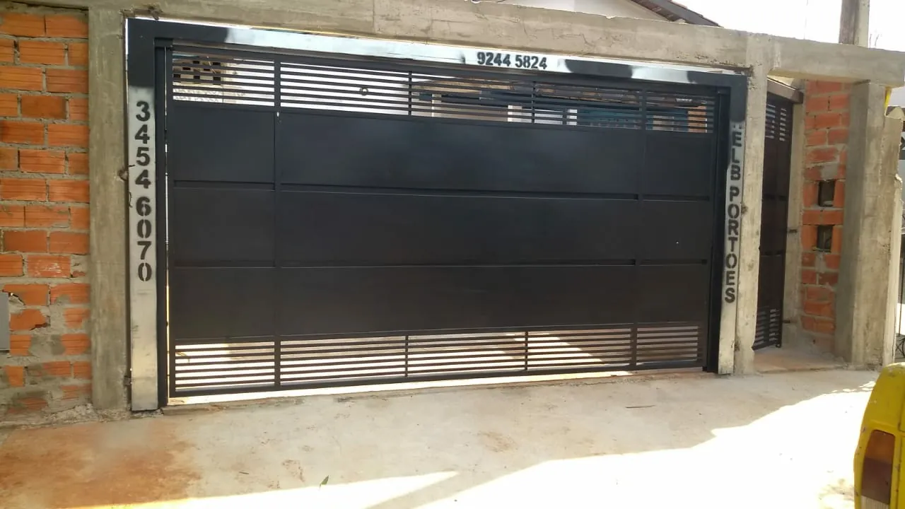 Portão de ferro instalado pela ELB Portões, com a placa da empresa na fachada